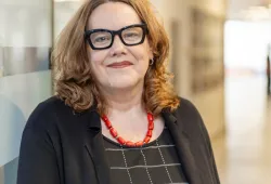photo of woman wearing glasses in front of a glass wall