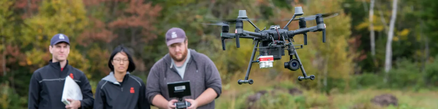 three technicians flying drone quadcopter