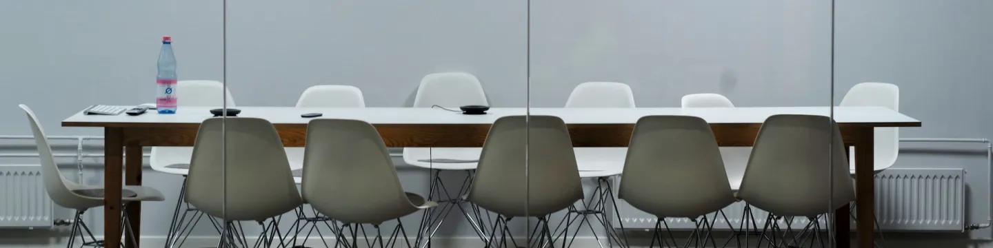 boardroom table with 12 white chairs