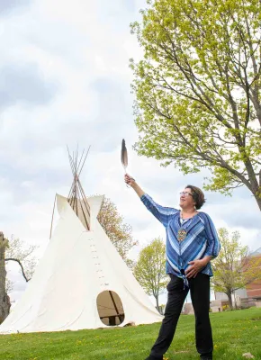Indigenous language instructor Doris Googoo holding an eagle feather