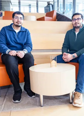 UPEI engineering students Syed Imran Ali and Syed Daniyal Ali sitting in a lit building atrium
