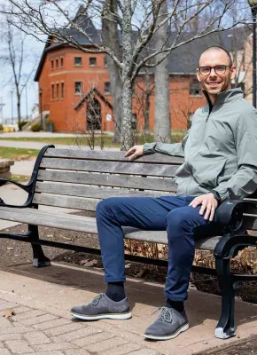 Peter Blanchard sitting on a bench in UPEI's quad