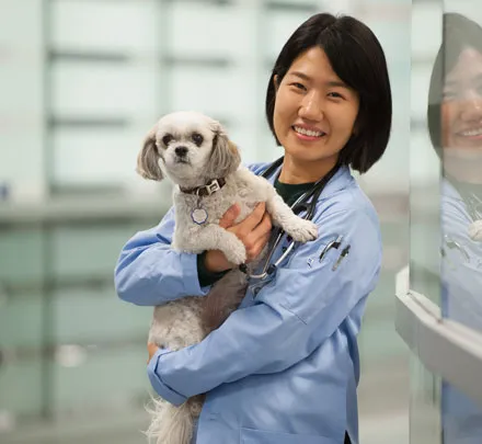 A student stands with a dog