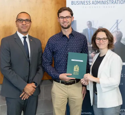 two faculty of business professors presenting a student award