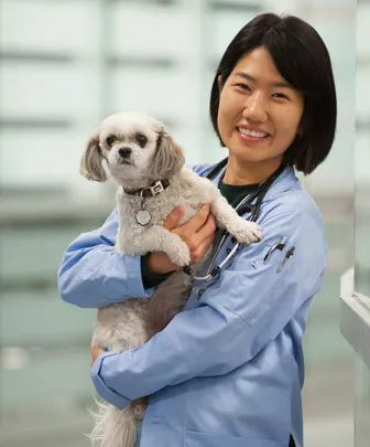 A student stands with a dog