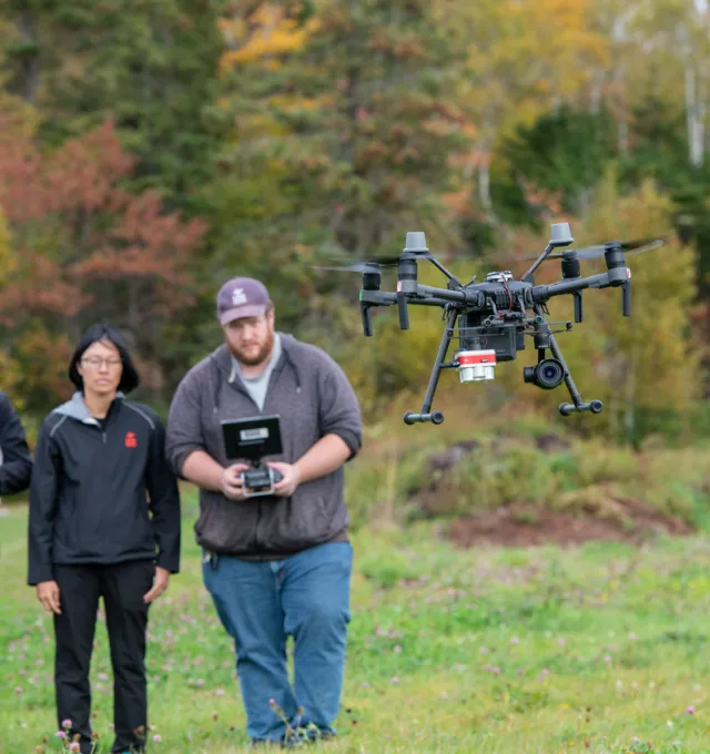 three technicians flying drone quadcopter