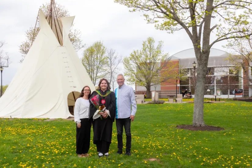 three people in front of the IKERAS tipi on UPEI's campus