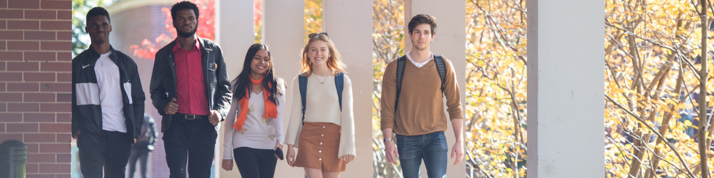 five students walking past Duffy Science Centre at UPEI