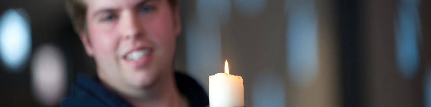 A student holds a candle