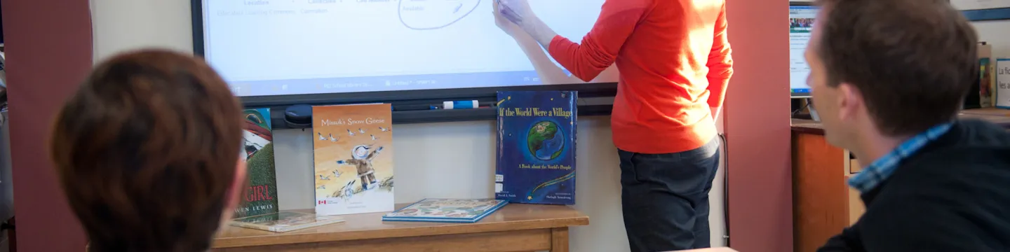 A woman writes on a smart board