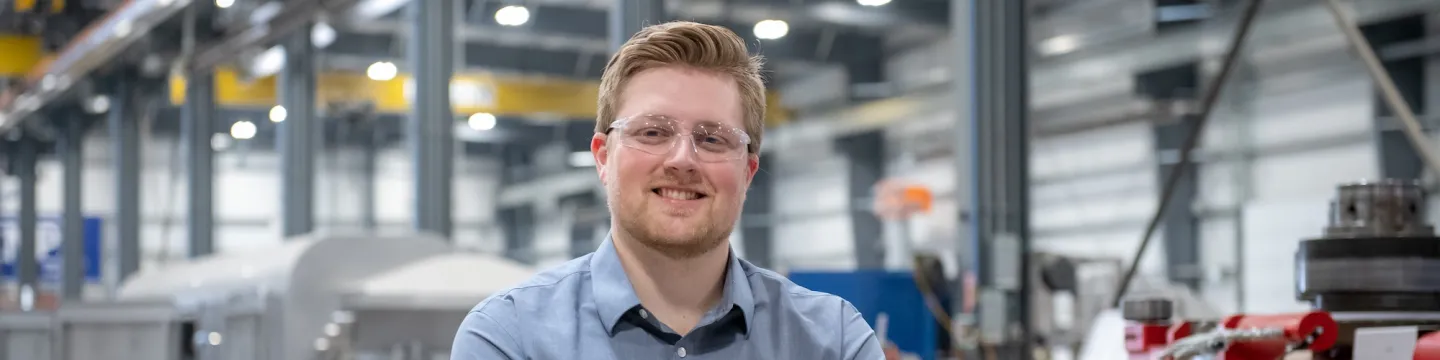 upei engineering graduate and professional engineer peter doiron sitting in a manufacturing warehouse bay