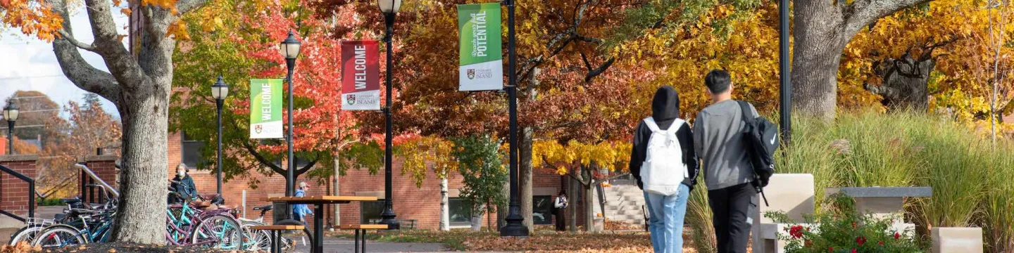 two students walking in the UPEI quad in Fall