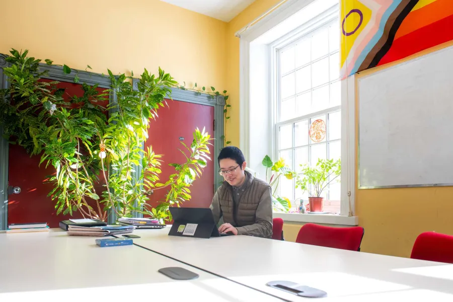 MAIS student Hexi Wang working in a student lounge