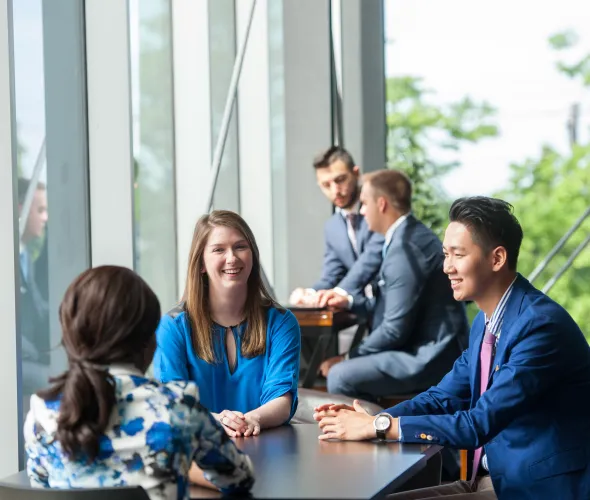 Students sit at a table talking