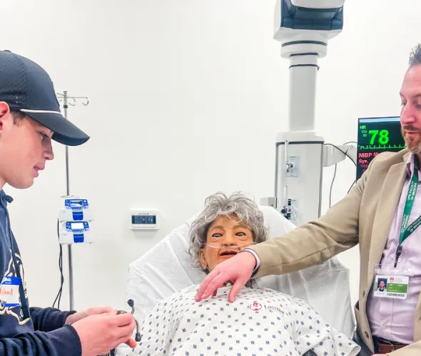 Jeff Clow (right), Director of Academic Affairs, UPEI Faculty of Medicine, shows Michael Gill (left), son of UPEI employees Anthony and Rebecca Gill, how to use a stethoscope on a manikin during a tour of the Clinical Learning and Simulation Centre in the Faculty of Medicine and Interprofessional Health Education Facility.
