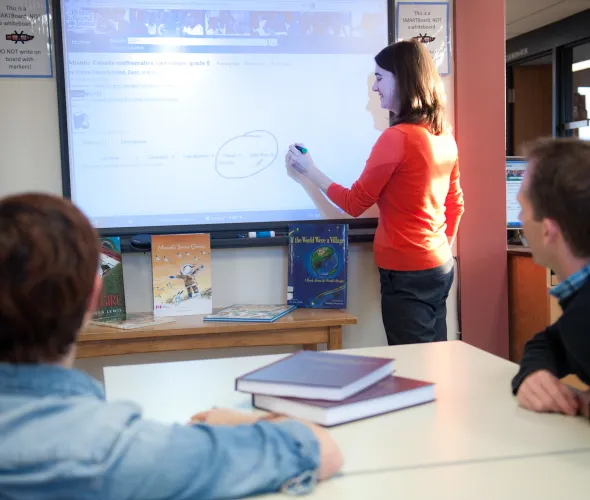 A woman writes on a smart board