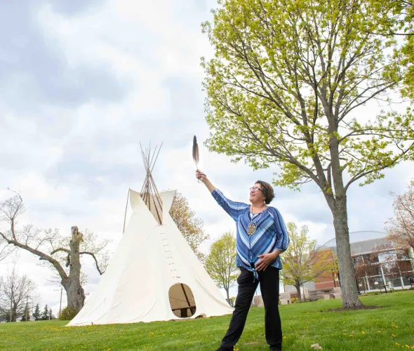Indigenous language instructor Doris Googoo holding an eagle feather