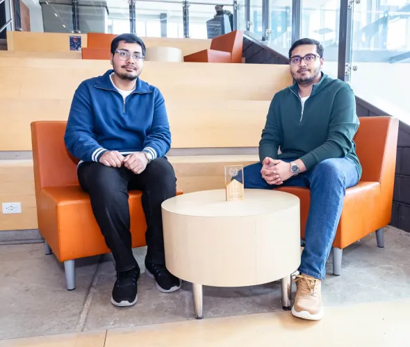 UPEI engineering students Syed Imran Ali and Syed Daniyal Ali sitting in a lit building atrium